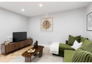 un soggiorno con divano verde e TV di Conveniently Situated - Luxuriously Furnished! a Londra