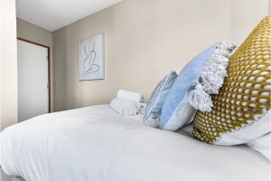 sypialnia z białym łóżkiem z poduszkami w obiekcie Gorgeous Flat, Perfect for Family/Large Group w Londynie