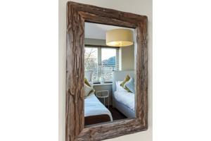 espejo con marco de madera en un dormitorio en Gorgeous Flat, Perfect for Family/Large Group en Londres
