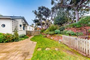 a yard with a fence and a house at Butterfly Landing in Pacific Grove