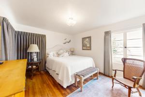 a bedroom with a bed and a desk and a window at Butterfly Landing in Pacific Grove