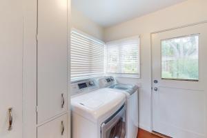 a white laundry room with a washer and dryer at Butterfly Landing in Pacific Grove