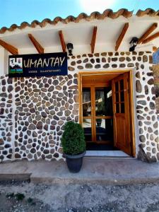 a building with a door and a sign on it at Hotel Humantay Lodge Ollantaytambo in Ollantaytambo
