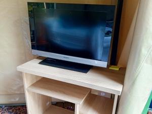 a flat screen tv sitting on a wooden stand at Glamping Colibrí, ubicado junto a bosque y cercano al parque a la vez in Jardin
