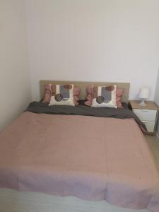 uma cama com um cobertor rosa e almofadas em Masha em Mamaia Nord – Năvodari
