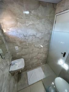 La salle de bains est pourvue d'une douche et d'un lavabo. dans l'établissement Suites Mar Azul, à São José da Coroa Grande