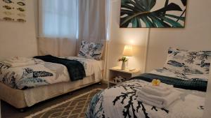 a bedroom with two beds with towels on them at The Boathouse a 3 Bedroom House in Narooma