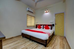 a bedroom with a large bed with red pillows at OYO Flagship Maple The Residence Near RDB Cinemas in Thākurdwari