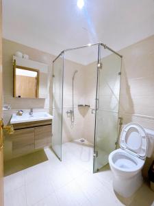 a bathroom with a shower and a toilet and a sink at Lá Homestay Apartment in Long Xuyên