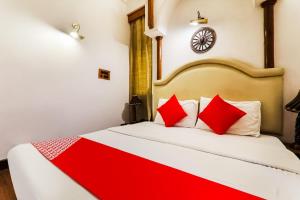 um quarto com uma cama grande e almofadas vermelhas em Resort Sita Kiran em Bareilly