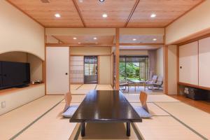 une salle à manger avec une table et des chaises noires dans l'établissement Furuya Ryokan, à Atami