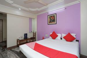 a bedroom with a large bed with red pillows at OYO Hotel Bliss Executive Near Sant Tukaram Nagar Metro Station in Chinchwad