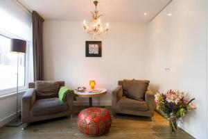 a room with two chairs and a table and a chandelier at Marigold Suite Studios in Amsterdam