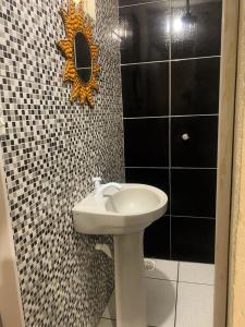 a bathroom with a sink and a mirror on the wall at Suíte Nativa - Flecheiras in Flecheiras