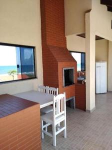 une salle à manger avec une table, des chaises et une cheminée dans l'établissement Apartamentos na Quadra do Mar, à Guaratuba