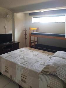 - une chambre avec un lit, une télévision et une fenêtre dans l'établissement Apartamentos na Quadra do Mar, à Guaratuba