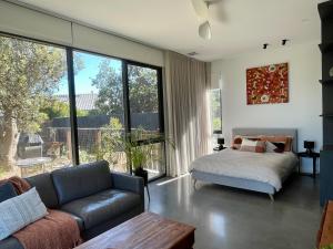 a living room with a couch and a bed at Tanderrum Guest Suite in Point Lonsdale