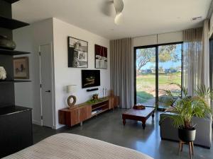 a bedroom with a bed and a living room with a tv at Tanderrum Guest Suite in Point Lonsdale