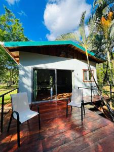 een patio met 2 stoelen en een huis bij Ficus house in Boca Tapada