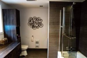 2 fotografías de un baño con ducha y aseo en Bel appartement au centre-ville, en Granby