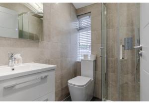 a bathroom with a toilet and a sink and a shower at Cozy and Stylish 2 BR flat in Greater London in London
