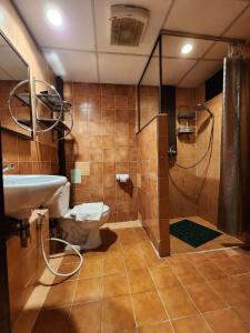 y baño con aseo, ducha y lavamanos. en Club One Seven Gaymen Chiang Mai, en Chiang Mai