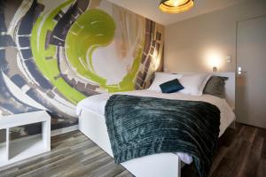 um quarto com uma cama com um quadro na parede em Maison 140m2 au calme - Beau jardin - à 15mn à pied du Centre-ville de COLMAR em Colmar