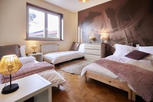 1 dormitorio con 2 camas y ventana en Maison 140m2 au calme - Beau jardin - à 15mn à pied du Centre-ville de COLMAR en Colmar