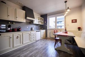 una cocina con armarios blancos y una mesa. en Maison 140m2 au calme - Beau jardin - à 15mn à pied du Centre-ville de COLMAR en Colmar