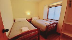 two beds in a small room with a window at Cumbres Nevadas in Coihaique