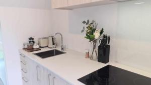 a white kitchen with a sink and a counter at Cute on Cashel 10 in Christchurch