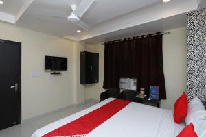a bedroom with a bed and a desk and a television at Flagship Richa Grand Inn Near Sahara Ganj Mall in Lucknow