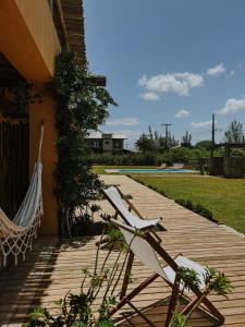 a couple of chairs and a hammock on a porch at Kahuma in Imbituba