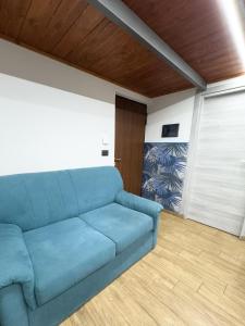 Sofá azul en una sala de estar con puerta en LUXURY LOFT, en Messina