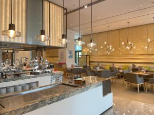 a restaurant with a bar and tables and chairs at Courtyard by Marriott Shanghai Hongqiao in Qingpu