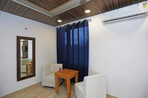 ein Wohnzimmer mit einem blauen Vorhang und einem Tisch in der Unterkunft Hotel Rosewood Inn in Rājpur