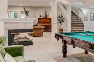 a living room with a pool table and a fireplace at Emerald Bay Luxury Retreat with Hot Tub in Calgary