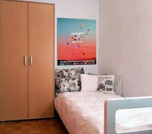 una camera da letto con un letto e un grande dipinto sul muro di Cosy single room with balcony in top location a Sarajevo