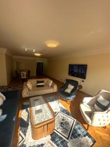 Una sala de estar con sofás y un televisor de pantalla plana. en كمباوند الخليج, en El Cairo 5 fotos más