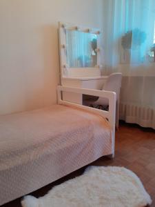 Dormitorio pequeño con cama y espejo en Cosy single room with balcony in top location, en Sarajevo