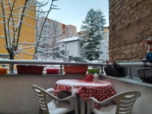 un tavolo e sedie su un balcone con neve di Cosy single room with balcony in top location a Sarajevo