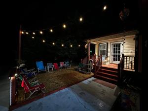un patio trasero con sillas y luces en una casa en Barbara's Dream, en Emerald Isle