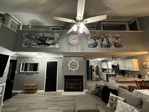 a living room with a ceiling fan and a fireplace at Barbara's Dream in Emerald Isle