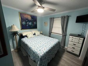 1 dormitorio con 1 cama y ventilador de techo en Barbara's Dream, en Emerald Isle