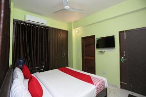 Flagship Near Anisabad Golambar في باتنا: غرفة نوم عليها سرير ومخدات حمراء
