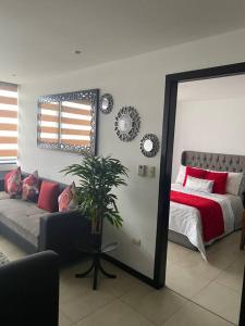 a bedroom with a bed and a mirror and a couch at Puerto santa Ana Torres Bellini in Guayaquil