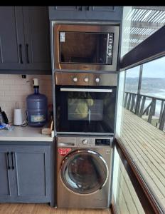 a kitchen with a washing machine and a microwave at Casa hermosa vista in Boca Pupuya