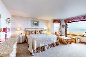 a bedroom with a bed and a large window at Rascals Oceanfront Retreat in Florence