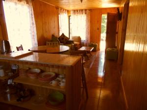 una sala de estar con paredes de madera y suelo de madera. en Cabañas en Chovellén, Pelluhue., en De Cauquenes
