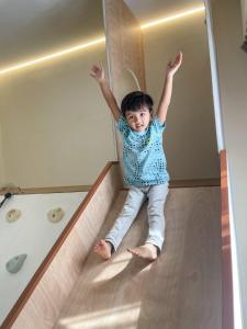 依斯干達公主城的住宿－KidsVille Slide Family Oasis JB Medini Legoland Malaysia，小孩坐在楼梯底部